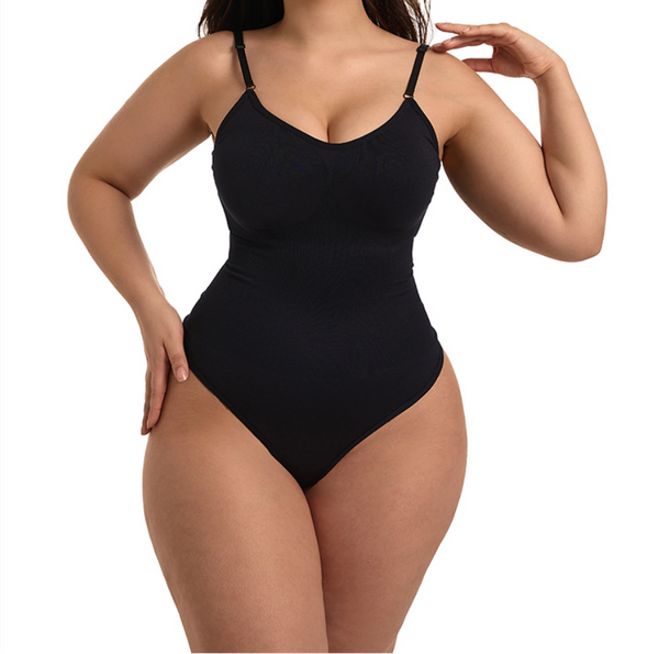 A plus-size model wearing a black ribbed one-piece bodysuit with thin shoulder straps, photographed against a solid white background.